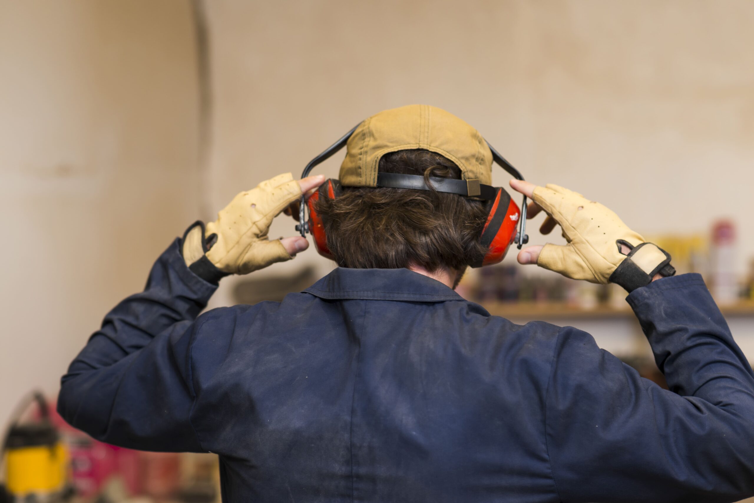 En el cuello, colgar auriculares insonorizados amarillos. protección  auditiva contra ruidos fuertes equipos de trabajo. se utilizan en obras de  construcción, instalaciones de producción con altos niveles de ruido.